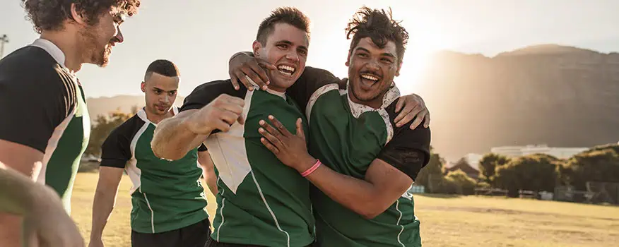 Rugby players celebrating a win, representing improved athletic performance and recovery from PRP therapy for sports injuries in Encinitas
