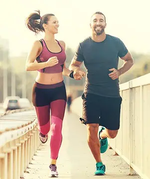 Man and woman jogging outdoors together, representing pain-free active living after laser therapy in Carlsbad